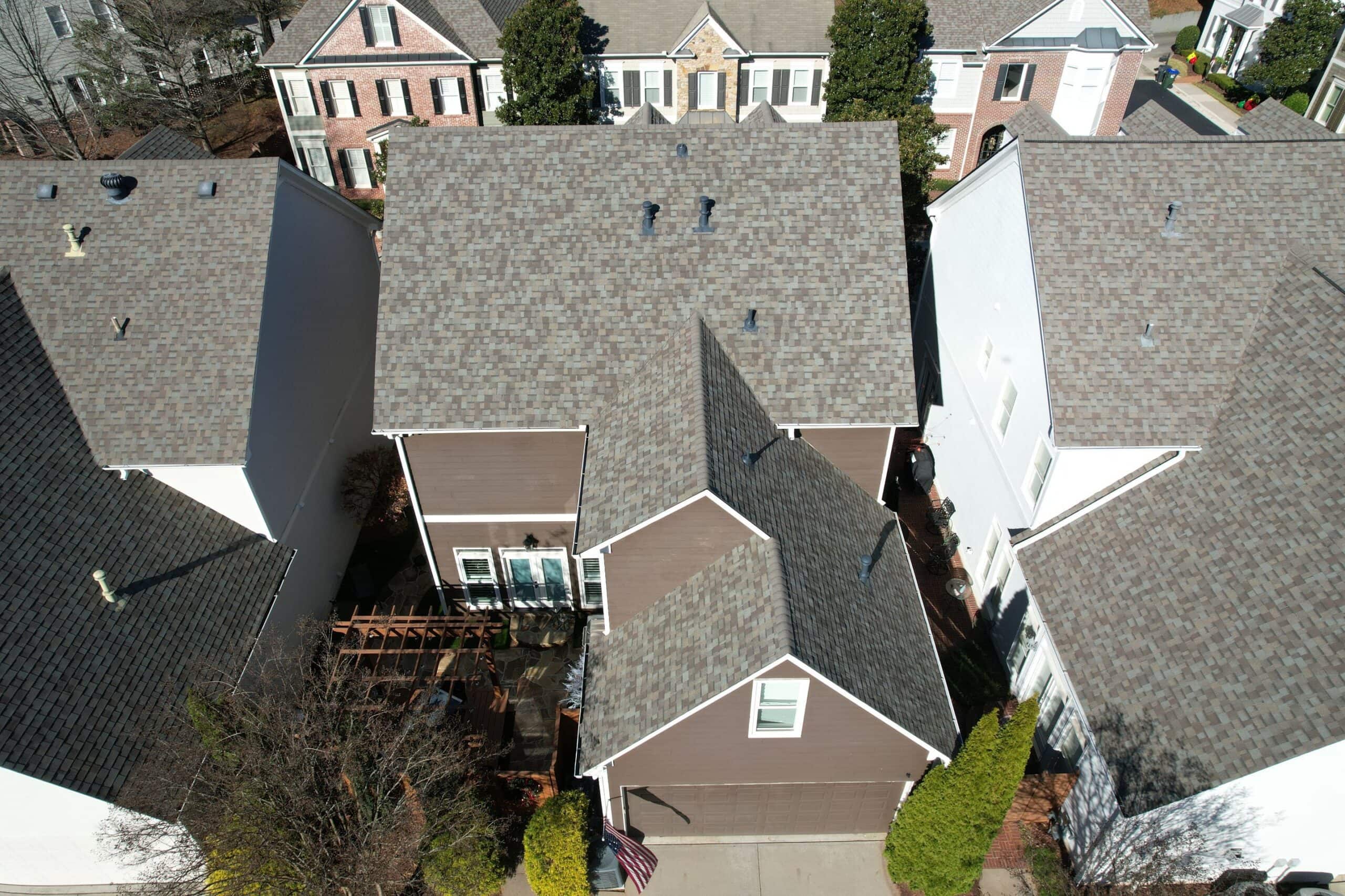 Aerial view of residential houses with well-maintained roofs, highlighting roofing quality and inspection solutions.
