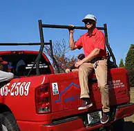 Professional roofer installing roofing materials on a red truck for residential projects.