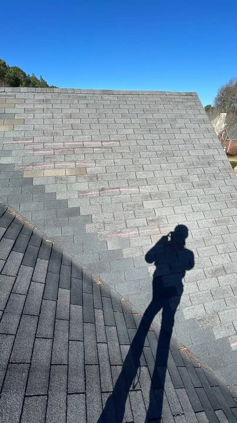 Wind damage roof inspection with marked shingles in Suwanee, GA