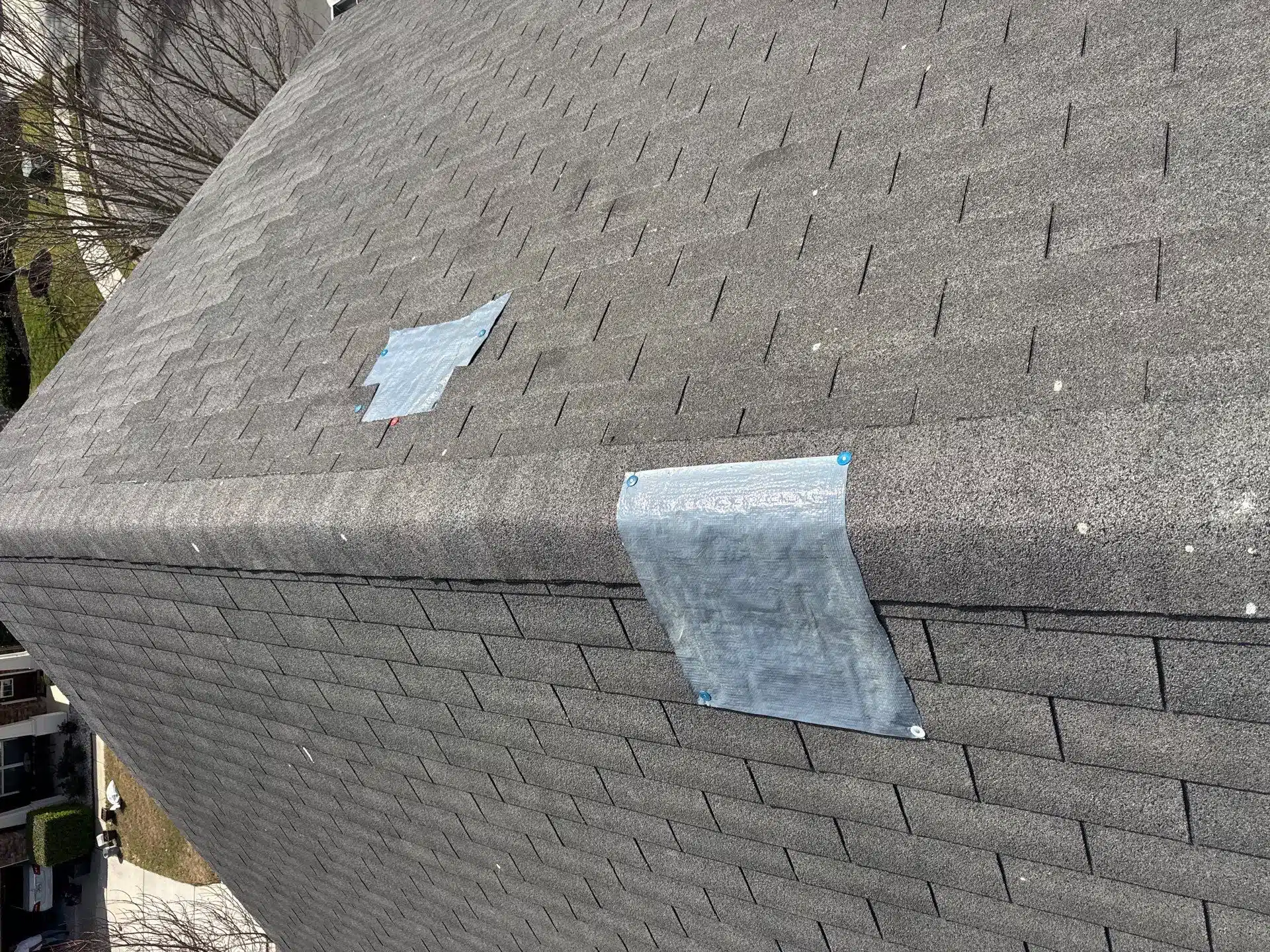 Emergency tarp installed over wind-damaged roof shingles in Lawrenceville, GA