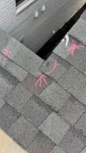 Close-up of an asphalt shingle repair area with sealant marks, documented by Inspector Roofing